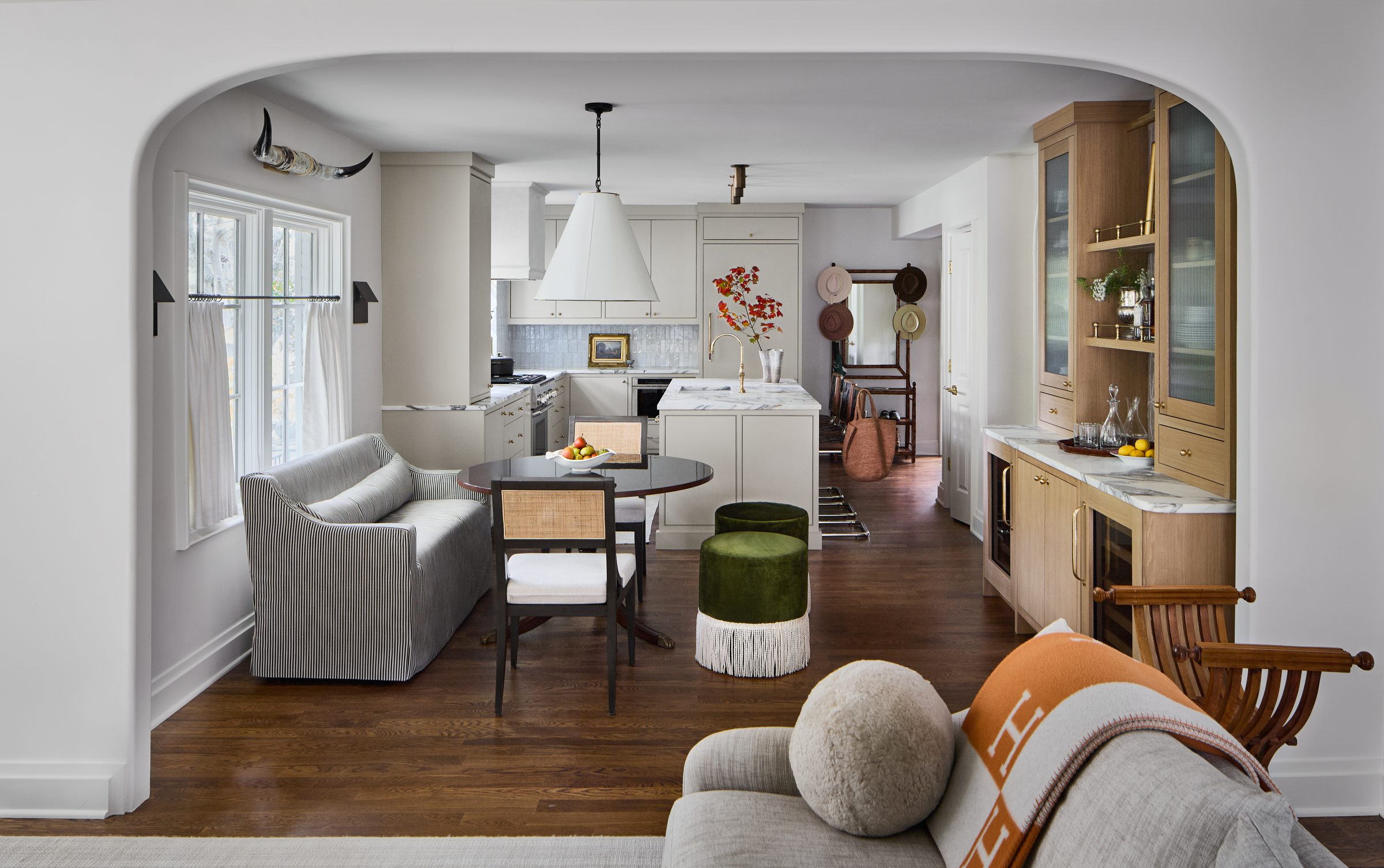Open kitchen, dining, and bar area with arched doorway, a recent Oak Hill Studio whole-home renovation