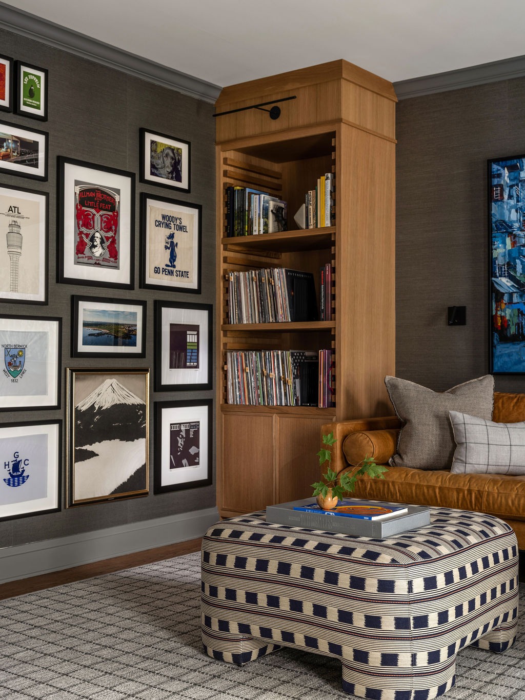 Den with built-in oak bookshelf, bamboo desk clock, and eclectic gallery wall