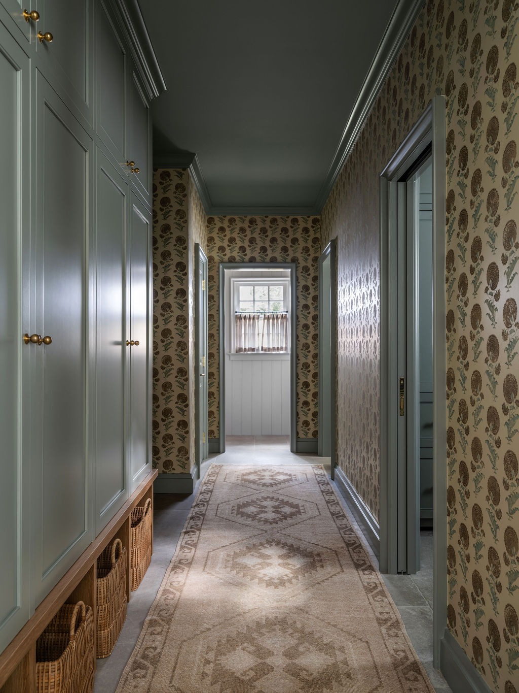 Mudroom hallway with block-print wallpaper and built-in storage cabinetry